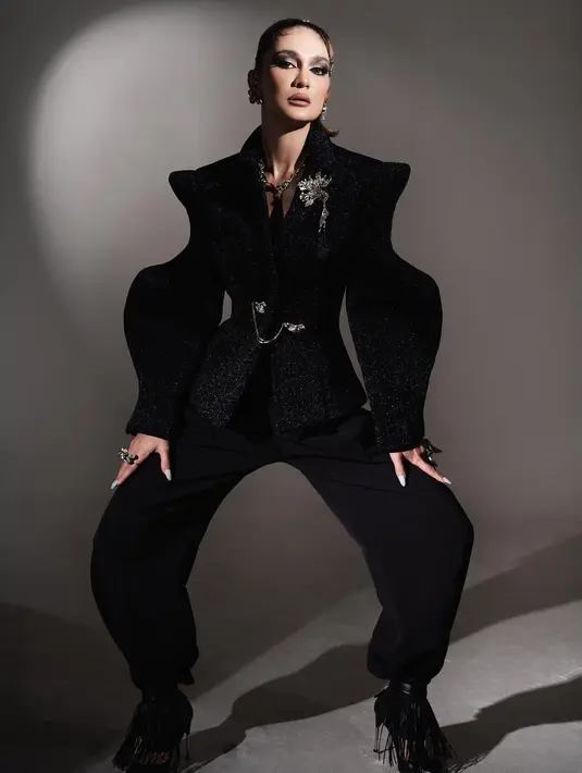 Penampilan unik dari Luna Maya. Photoshoot dengan all black outfit. Structured outer dan celana panjang hitam berpadu sempurna dengan aksesori, makeup bold, dan tatanan rambut Luna Maya. Foto: Instagram.