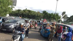 Petugas mengatur kendaraan di sekitar kawasan Monas, Jakarta, Senin (1/1). Kurangnya pengawasan menyebabkan banyak PKL dan parkir liar memenuhi kawasan tersebut sehingga menimbulkan kesemrawutan. (Liputan6.com/Immanuel Antonius)