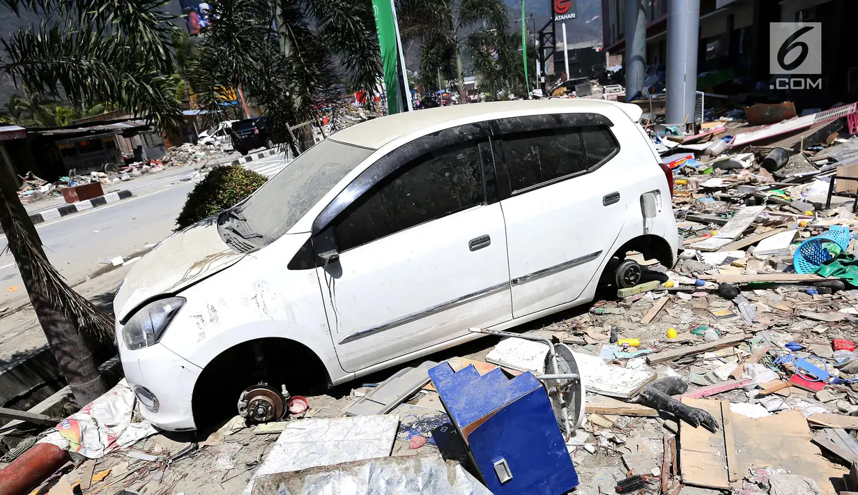 Mobil Daihatsu Ayla menjadi incaran jarahan korban gempa dan tsunami di Palu Grand Mal, Palu, Jumat (5/10). Warga korban gempa bumi mengambil ban dan interior mobil. (Liputan6.com/Fery Pradolo)