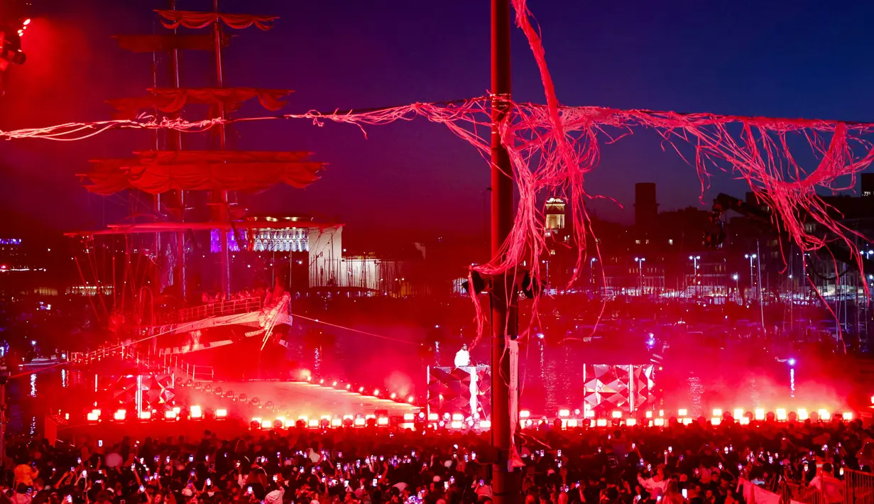 Sejumlah masyarakat prancis menikmati pertunjukan musik saat upacara penyambutan kedatangan api Olimpiade dan Paralimpiade Paris 2024 di Vieux-Port (Pelabuhan Tua) Marseille, Pranci, Rabu (08/05/2024) waktu setempat. (AFP/Pool/Ludovic Marin)