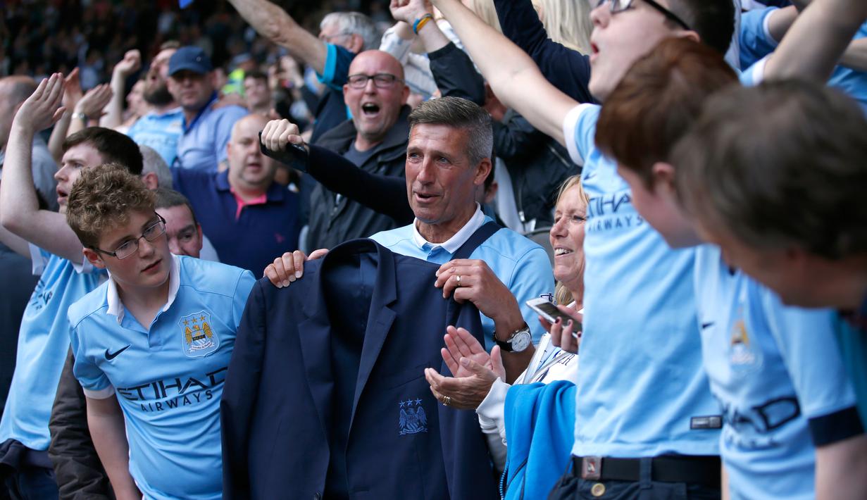 Salah satu suporter Manchester City menerima Jaket yang diberikan Pelatih Manuel Pellegrini di Stadion Liberty, Inggris (15/5). Pellegrini akan digantikan Pep Guardiola yang sebelumnya menangani Bayern Muenchen. (Reuters /Rebecca Naden)