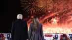 Presiden terpilih Amerika Serikat (AS) Donald Trump dan istrinya Melania Trump menyaksikan kembang api saat resepsi di Trump National Golf Club Washington DC, Sterling, Virginia, pada 18 Januari 2025. (Alex Brandon/POOL/AFP)