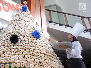 Karyawan menghiasi pohon Natal yang terbuat dari susunan donat di lobby hotel Dafam Semarang, Rabu (12/12). Pohon Natal setinggi 3 meter untuk menyambut Natal tersebut terdapat 2000 buah kue donat. (Liputan6.com/Gholib)