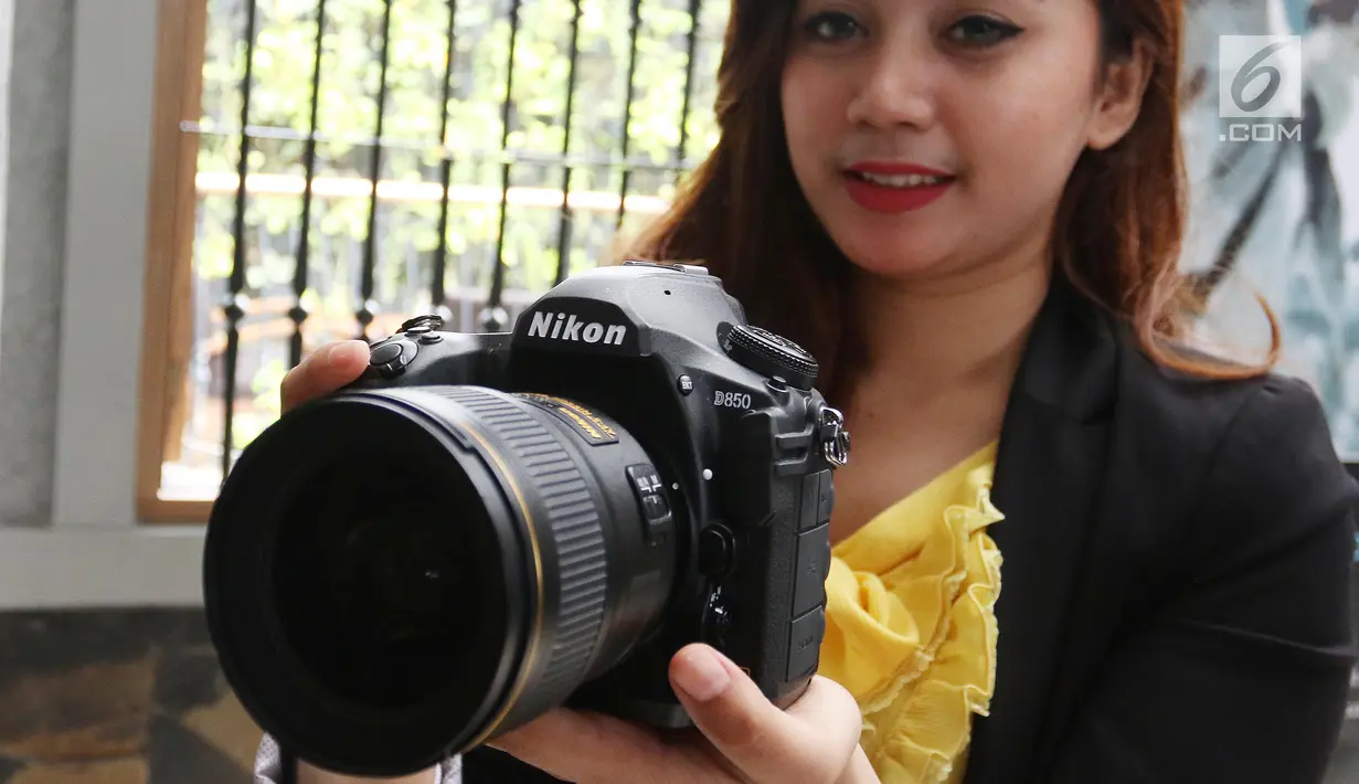 Seorang model berpose sambil menunjukkan kameran Nikon D850 saat peluncuran di Jakarta, Senin (29/1). Keunggulan lain kamera ini adalah sistem 153-point AF, selain itu bisa merekam video full frame dengan kualitas 4K UHD. (Liputan6.com/Angga Yuniar)
