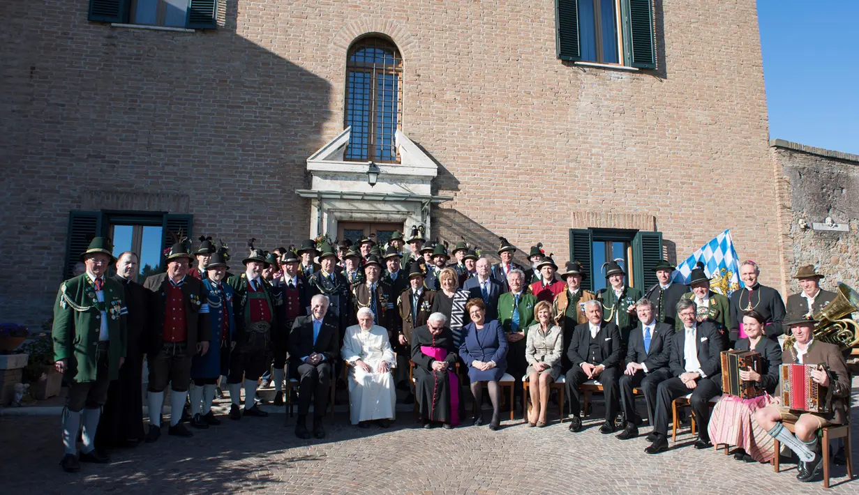 Paus Emeritus Benediktus XVI berfoto bersama delegasi dari Bavaria saat ulang tahunnya yang ke-90 di Vatikan (17/4). Ulang tahun Paus Benediktus bertepatan pada hari Minggu Paskah tahun ini.  (L'Osservatore Romano/Pool Photo via AP)