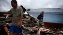 Seorang pria dan wanita mencari barang-barang di mana rumah mereka berdiri sebelum gempa dan tsunami di desa Wani, Palu, Kamis (4/10). Gempa bumi berkekuatan 7,4 skala richter melanda Palu dan Donggala pada 28 September 2018 lalu. (AP/Dita Alangkara)