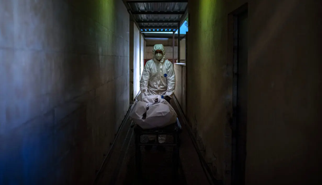Petugas kamar jenazah membawa jenazah korban COVID-19 di kamar jenazah sebuah rumah sakit di Barcelona, Spanyol, 5 November 2020. Seperti dokter dan perawat, petugas kamar jenazah adalah bagian dari sekelompok pekerja penting di tengah pandemi. (AP Photo/Emilio Morenatti)