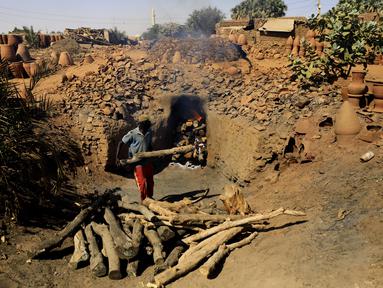Seorang perajin Sudan membakar tembikar di Khartoum, Sudan (20/10/2020). Para perajin tembikar di Sudan memanfaatkan tanah liat sisa banjir untuk membuat benda-benda kerajinan tersebut. (Xinhua/Mohamed Khidir)