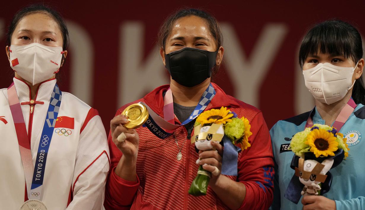 Medali emas di Olimpiade Tokyo diraihnya usai menyingkirkan unggulan dari Cina, Liao Qiuyun, yang akhirnya meraih perak. Hidilyn Diaz total mengangkat barbel seberat 224 kg, unggul 1 kg dari Liao Qiuyun. (Foto: AP/Luca Bruno)