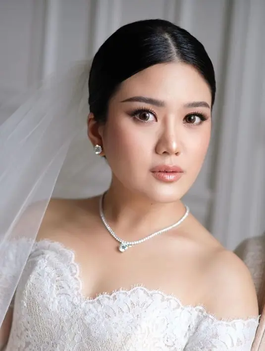 Penampilan Valencia disempurnakan dengan pulasan makeup flawless nuansa peach yang segar. Serta tatanan updo yang simpel dan timeless.  [Foto: IG/vanny.adelina].