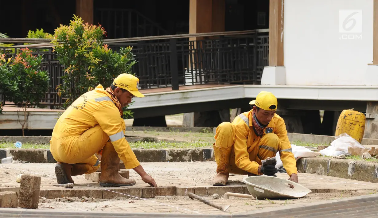 Petugas melakukan perbaikan di depan salah satu ruang pertemuan di Setu Babakan, Jakarta, Jumat (14/7). Setu Babakan akan menjadi lokasi pelaksanaan Lebaran Betawi 2017 yang akan digelar pada 21 - 23 Juli 2017. (Liputan6.com/Helmi Fithriansyah)
