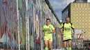 Martina Schliep (kiri) dan Gaston Pruefer berlari di sisi timur Tembok Berlin, Jerman, (11/8/2014). (AFP PHOTO/Tobias Schwarz)