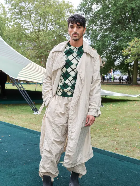 Pemeran The Kissing Booth 2, Taylor Zakhar Perez mengenakan sweater kotak-kotak hijau yang dipadukan dengan trench coat dan long pants warna senada. [Dok/Burberry]