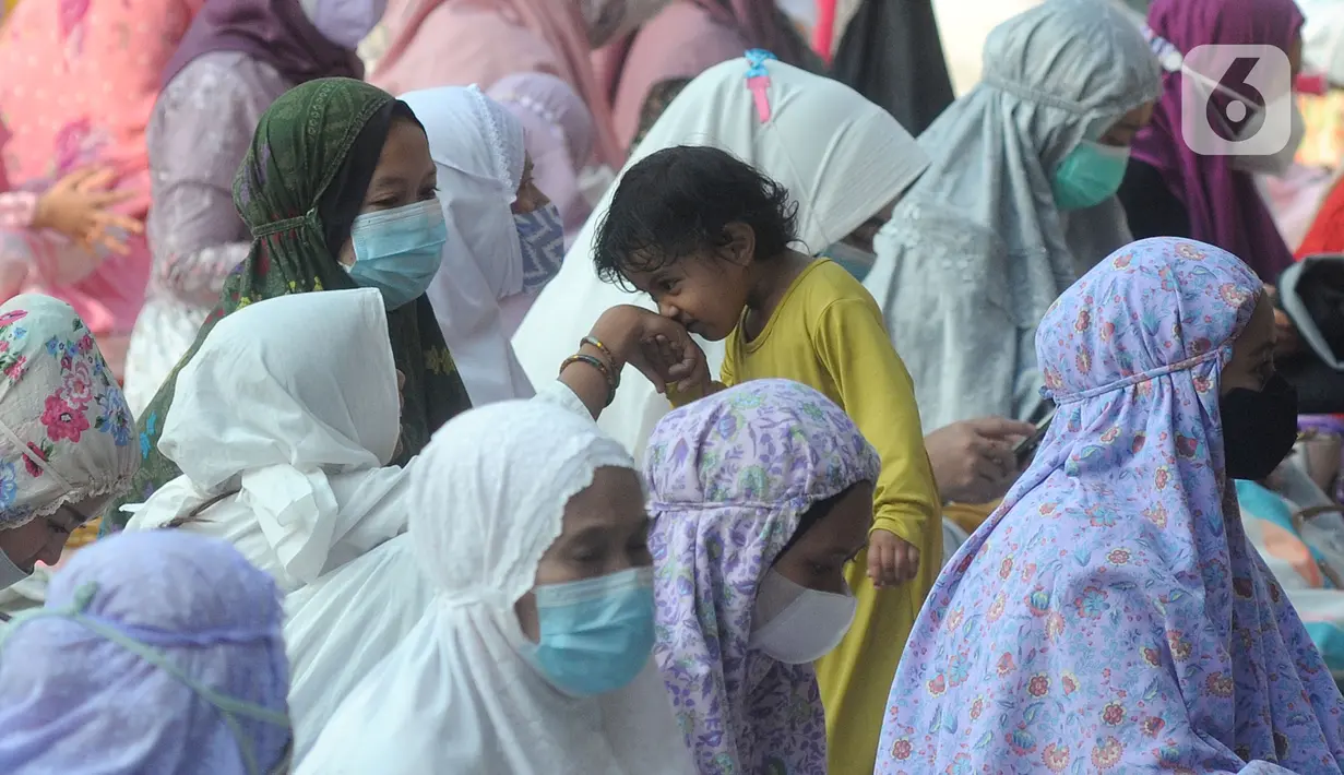 Seorang anak mencium tangan saat sholat Idul Fitri di Masjid Kubah Emas, Depok, Jawa Barat, Kamis (13/5/2021). Hari ini seluruh umat Islam dunia merayakan Hari Raya Idulfitri 1442 Hijriah setelah menjalankan ibadah puasa satu bulan penuh di bulan suci Ramadhan. (merdeka.com/Arie Basuki)