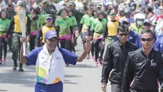 Legenda taekwondo Indonesia, Abdul Rojak, membawa obor Asian Games saat melintasi di Banjarmasin, Kalimantan Selatan, Senin (30/7/2018). Sebanyak 53 kota di Indonesia akan dilalui oleh obor Asian Games. (Bola.com/Reza Bachtiar)