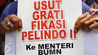 Pengunjuk rasa dari Gerakan Nasionalisasi Aset (GANAS) menunjukkan poster berisi tuntutan saat aksi di depan kantor Kementerian BUMN, Jakarta, Selasa (6/10). Mereka menuntut Dirut Pelindo II RJ Lino turun dari jabatannya. (Liputan6.com/Immanuel Antonius)