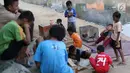 Anak-anak bermain di bantaran anak Sungai Ciliwung, Jakarta, Rabu (6/6). Meskipun tidak layak sebagai tempat bermain, namun lokasi itu menjadi tempat bagi anak-anak di kawasan tersebut untuk menunggu waktu berbuka. (Liputan6.com/Immanuel Antonius)