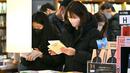 Orang-orang yang memakai masker membaca buku di toko buku di Seoul, setelah Korea Selatan mencabut mandat masker dalam ruangan saat kasus COVID-19 yang terus menurun, Senin (30/1/2023). Mulai Senin, orang dapat mengunjungi sebagian besar tempat tanpa masker  karena pemerintah mencabut mandat penggunaan masker dalam ruangan yang telah diberlakukan sejak Oktober 2020. (Jung Yeon-je / AFP)