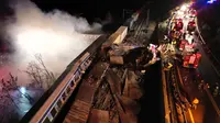 Asap mengepul dari kereta saat petugas pemadam kebakaran dan penyelamat beroperasi pada 1 Maret 2023, setelah tabrakan 2 kereta di dekat Kota Larissa, Yunani, Selasa 28 Februari 2023 malam. (Vaggelis Kousioras/AP)