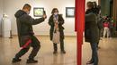 Seorang perempuan berpose untuk foto di galeri di Museum Seni Nasional China di Beijing, Rabu (1/2/2023). Pengunjung terus berduyun-duyun ke museum, situs bersejarah, dan tempat wisata di ibu kota China saat periode liburan Tahun Baru Imlek berakhir. (AP Photo/Mark Schiefelbein)