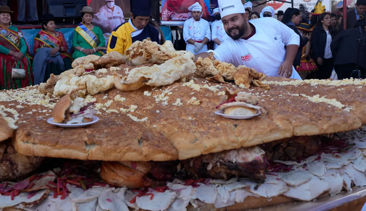 Para ahli gastronomi dan mahasiswa koki menyiapkan "Sandwich de Chola" pada hari Selasa dalam upaya memecahkan rekor dunia untuk sandwich terbesar. (AP Photo/Juan Karita)