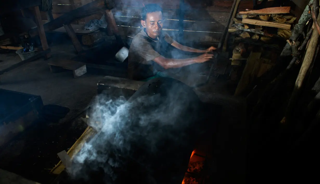 Seorang pria memanggang biji kopi robusta menggunakan alat tradisional di salah satu industri rumah tangga di Ulee Kareng, Aceh, Rabu (20/11/2019). Kopi yang diolah secara tradisional itu dijual dengan kisaran harga beragam tergantung kualitas. (CHAIDEER MAHYUDDIN/AFP)