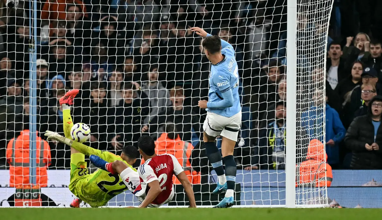 Pemain Manchester City, John Stones, mencetak gol ke gawang Arsenal pada laga Liga Inggris di Stadion Etihad, Minggu (22/09/2024). (AFP/Paul Ellis)