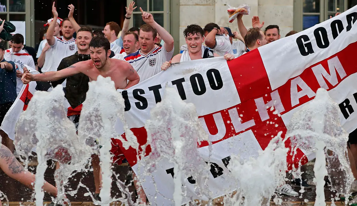 Sejumlah suporter Inggris masuk ke kolam air mancur yang berada di tengah Kota Lille, Prancis (16/6). Aksi ini mereka lakukan setelah mengatahui Timnas Inggris berhasil mengalahkan Wales dalam pertandingan piala Eropa 2016. (REUTERS / Wolfgang Rattay)