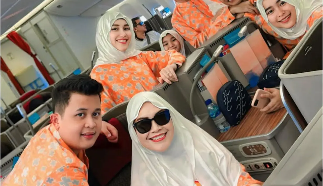 Bersama keluarganya, Ayu Ting Ting berangkat ke tanah suci. Mereka tampil kompak mengenakan seragam warna orange dipadukan kerudung putih untuk perempuan. [@ayutingting92]