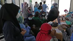 Sejumlah guru menunggu untuk vaksin COVID-19 di Puskesmas Jatiasih, Bekasi, Jawa Barat, Jumat (9/4/2021). Kementerian Pendidikan dan Kebudayaan menargetkan sebanyak 5,5 juta guru dan tenaga pendidik mengikuti vaksinasi COVID-19 sampai akhir Juni 2021. (Liputan6.com/Herman Zakharia)