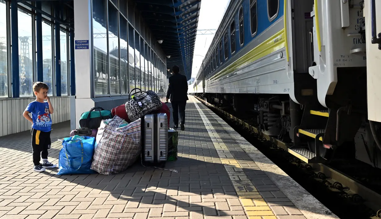<p>Seorang anak berdiri di dekat bagasi, salah satu dari ribuan perempuan dan anak-anak yang melarikan diri dari Ukraina setelah Rusia menginvasi, tiba dari Polandia, di stasiun kereta api Kiev pada 12 Mei 2022. Untuk pertama kalinya sejak awal perang, penghitungan resmi di perbatasan pada 10 Mei menunjukkan 29.000 orang melintasi perbatasan untuk pergi, sedangkan 34.000 orang lainnya melintasi perbatasan untuk kembali ke Ukraina. (Sergei SUPINSKY / AFP)</p>