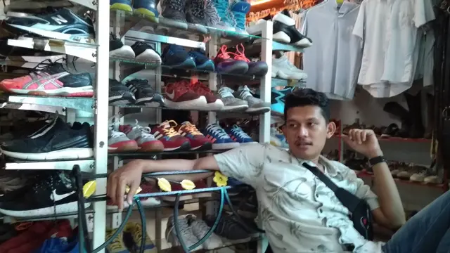 Seorang lelaki berdiri di dekat rak sepatu toko "Tgk. Monja Klass" (Liputan6.com/Rino Abonita)