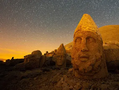 Patung kepala batu besar di situs arkeologi Gunung Nemrut, Adiyaman, Turki, 17 September 2021. Situs arkeologi Gunung Nemrut ditetapkan menjadi Situs Warisan Dunia UNESCO sejak tahun 1987. (YASIN AKGUL/AFP)