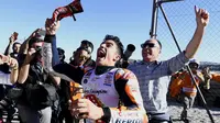 Marc Marquez melempar sarung tangan kepada fans usai mengunci gelar juara dunia MotoGP 2017 pada balapan MotoGP Valencia di Ricardo Tormo Circuit, Cheste, (12/11/2017). Gelar tersebut merupakan yang keempat buat Marquez.  (AFP/Jose Jordan)