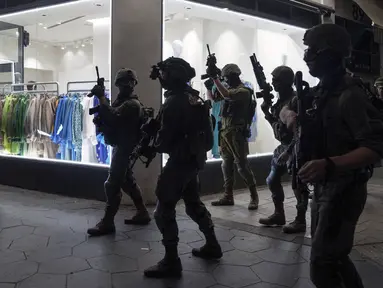 Pasukan keamanan mencari penyerang dekat lokasi penembakan di Tel Aviv, Israel, 7 April 2022. Pejabat kesehatan Israel mengatakan dua orang tewas dan sedikitnya delapan lainnya terluka dalam penembakan di Tel Aviv. (AP Photo/Ariel Schalit)