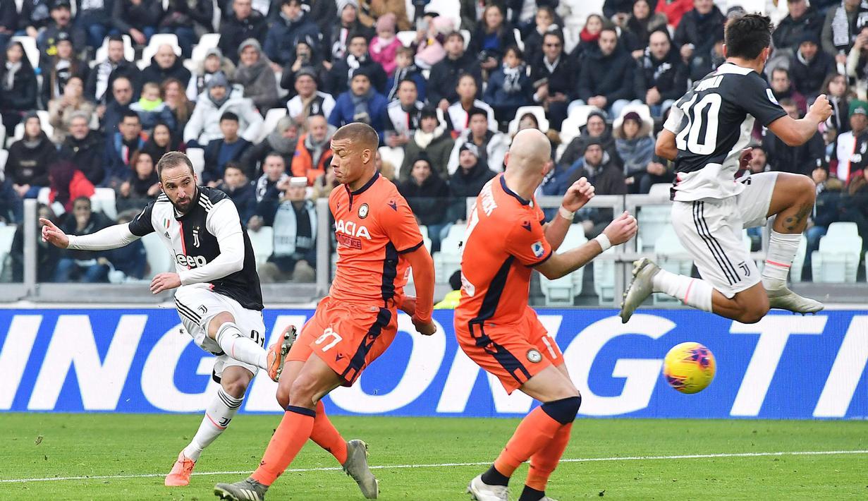 Penyerang Juventus, Gonzalo Higuain (kiri) menendang bola dari kawalan dua pemain Udinese pada pertandingan lanjutan Liga Serie A Italia di Stadion Allianz di Turin (15/12/2019). Juventus menang 3-1 atas Udinese. (Alessandro Di Marco / ANSA via AP)