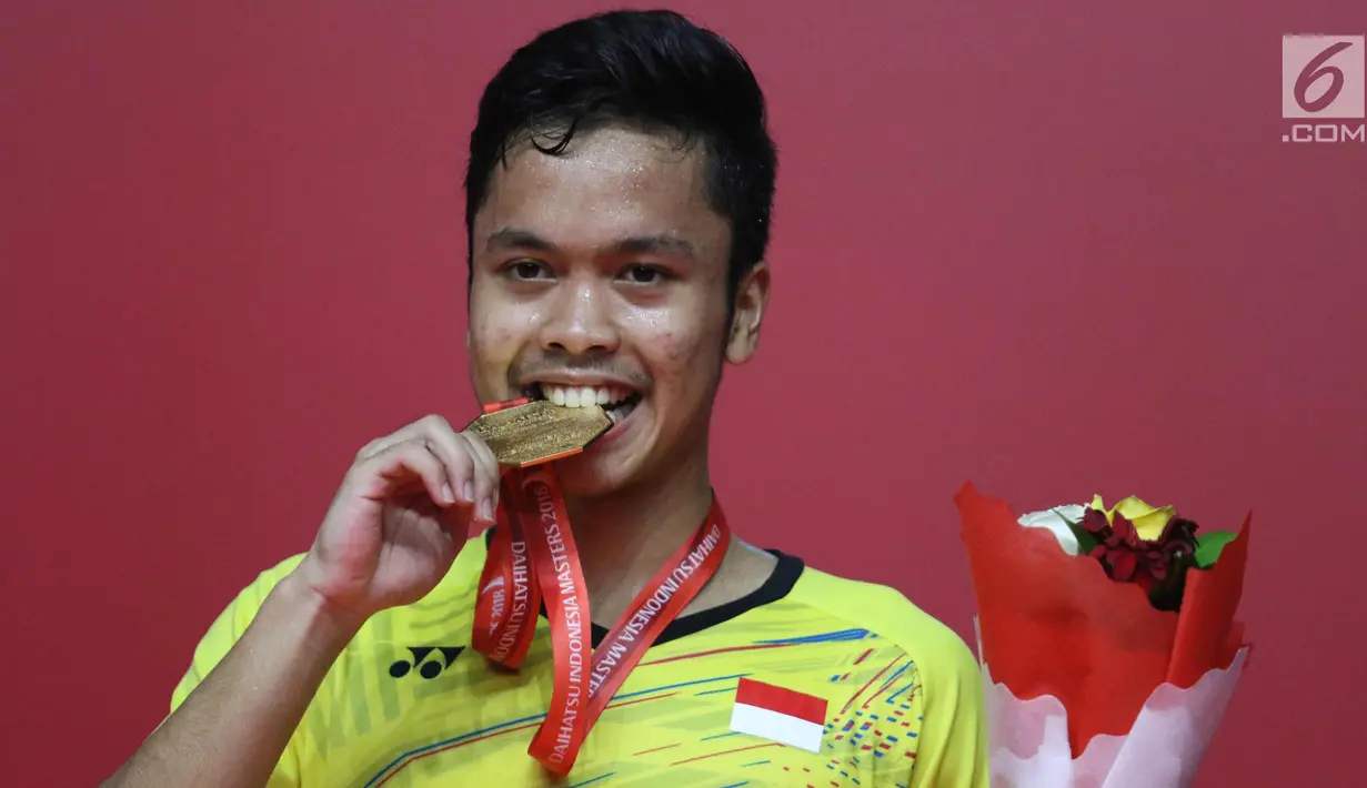 Pebulu tangkis Indonesia, Anthony Ginting mengigit medali saat meraih juara Indonesia Masters 2018 di Senayan, Jakarta, Minggu (28/1). Anthony menang dengan skor 21-13 dan 21-12 atas pebulu tangkis asal Jepang, Kazumasa Sakai. (Liputan6.com/Angga Yuniar)