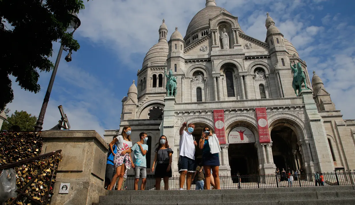 Wisatawan berjalan-jalan di basilika Sacre Coeur di distrik Montmartre, Paris pada Senin (10/8/2020). Penggunaan masker mulai hari Senin (10/8) diwajibkan di area luar ruangan yang ramai di ibu kota Prancis itu untuk mengendalikan peningkatan tingkat infeksi virus corona. (AP Photo/Michel Euler)
