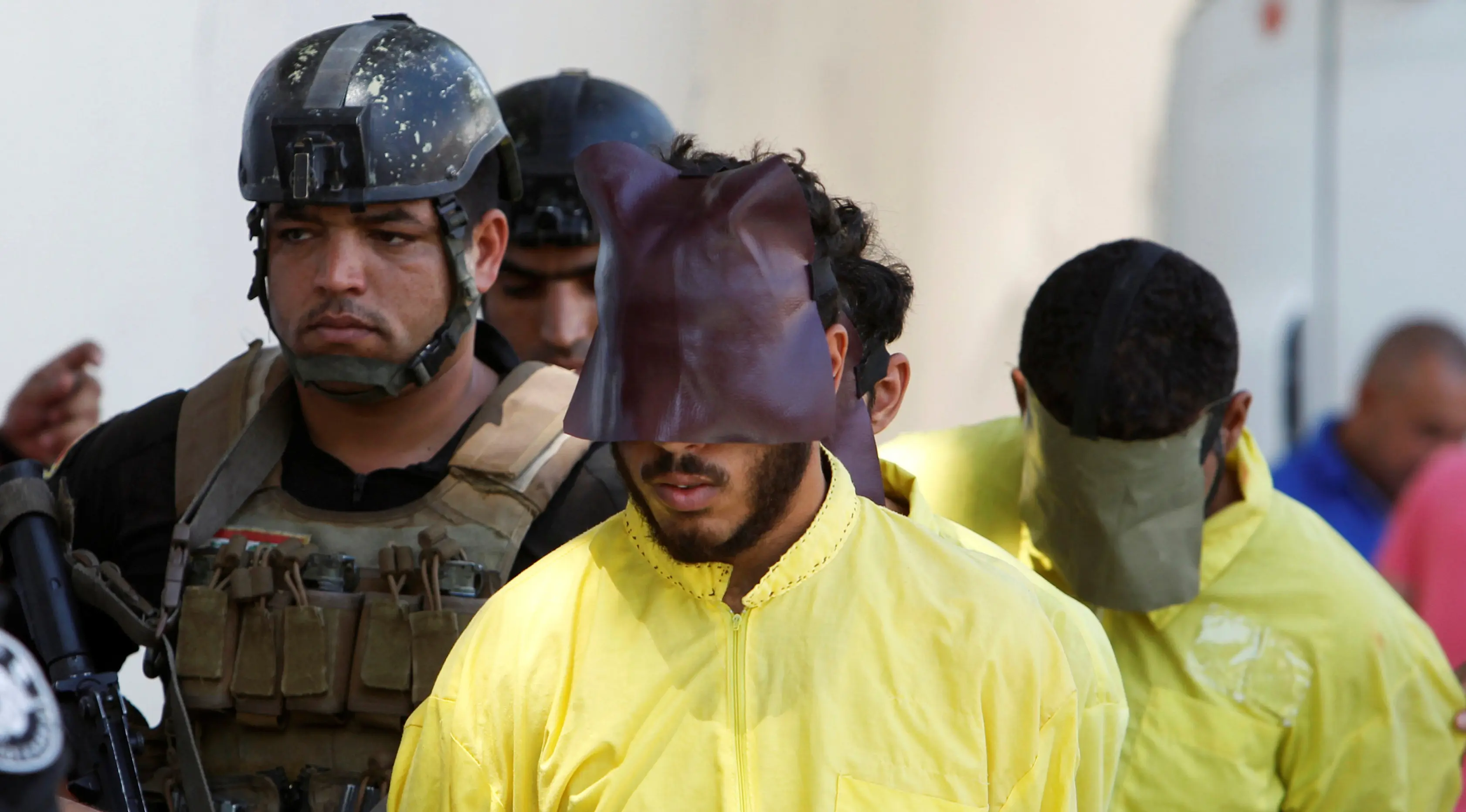 Militer Irak mengawal sejumlah pria yang diduga militan ISIS saat akan konferensi pers di Baghdad, Irak (7/9). Militer Irak menangkap beberapa militan ISIS usai kembali merebut wilayah yang dikuasai. (REUTERS/Khalid al Mousily)