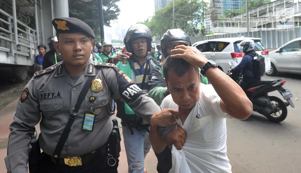 Terduga copet menutupi kepalanya dengan tangan saat akan diamankan menuju Mapolda Metro Jaya di Jalan Jenderal Sudirman, Jakarta (2/4). Polisi mengamankan tiga terduga copet. (Merdeka.com/Arie Basuki)