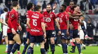 Gelandang Lille asal Aljazair #06, Nabil Bentaleb (C,  bek Lille asal Belgia #12, Thomas Meunier (R), dan rekan-rekan setim mereka merayakan kemenangan setelah memenangkan pertandingan sepak bola L1 Prancis antara Olympique de Marseille (OM) dan Lille OSC di Stade Velodrome di Marseille, Prancis selatan pada 22 Maret 2026. (Pascal POCHARD-CASABIANCA/AFP0