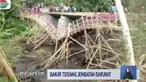 Akibat terjangan banjir, warga terpaksa memutar mencari jalan lain untuk menyeberang.