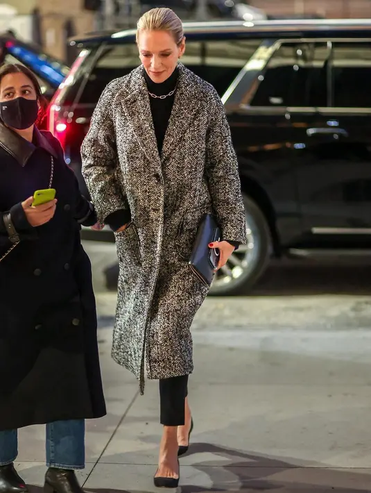 Uma Thurman memakai coat tweed oversized, ribbed turtleneck, knit cargo pants, dan kalung Roxanne Chain. (Foto: Tory Burch)