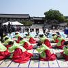 Wanita dan pria mengenakan gaun tradisional Korea Selatan membungkuk selama upacara untuk menghidupkan kembali Hari Kedewasaan ke-50 di Desa Hanok Namsangol di Seoul, Korea Selatan (16/5/2022). Upacara diadakan untuk pria dan wanita muda yang akan berusia 20 tahun. (AP Photo/Lee Jin-man)