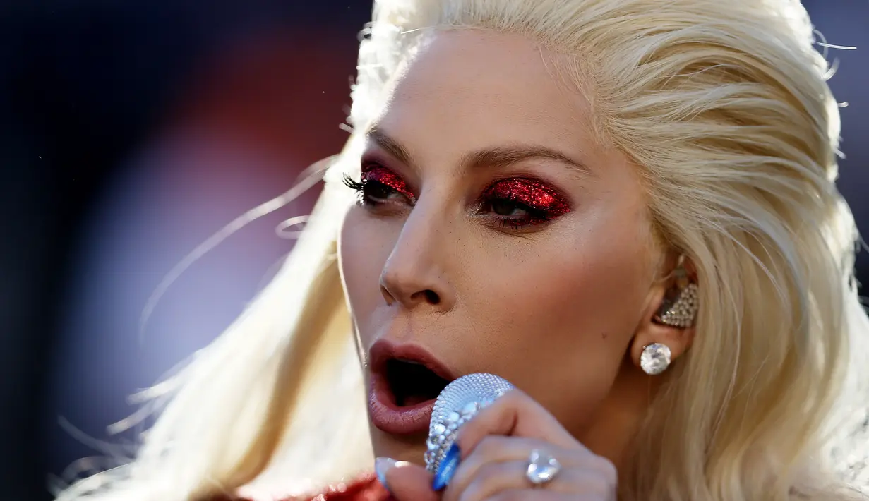 Ekspresi Lady Gaga saat menyanyikan lagu kebangsaan AS pada pembukaan Super Bowl 50 di Santa Clara, California, Minggu (7/2). Mengenakan busana dari Gucci, Mother Monster itu tampil serba merah seperti bendera negaranya. (Patrick Smith/Getty Images/AFP)