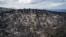 Pemandangan udara menunjukkan kerusakan yang disebabkan oleh kebakaran hebat di dekat Desa Mati, dekat Athena, Selasa (24/7). Selain menewaskan 74 orang, 170 lainnya terluka dalam kebakaran hutan tersebut. (Savas Karmaniolas/AFP)