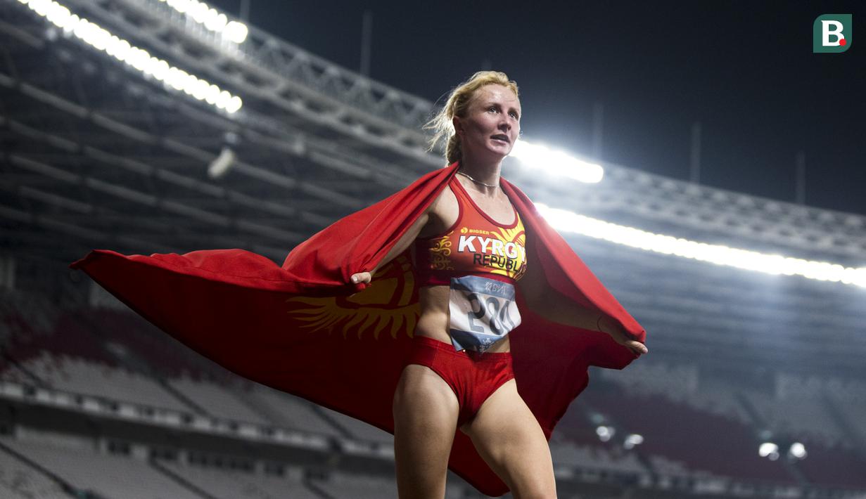 Pelari Kirgistan, Daria Maslova, merayakan kemenangan pada nomor 5.000 meter cabang atletik Asian Games di SUGBK, Jakarta, Selasa (28/8/2018). (Bola.com/Vitalis Yogi Trisna)