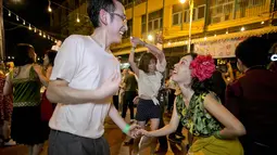 Pria dan wanita menari di depan kuil Phra Pathom Chedi di provinsi Nakhon Pathom, Thailand (25/2). Lebih dari 300 peserta termasuk penari asing bernari menghebohkan sebuah jalan sekitar satu jam. (AFP Photo/Thai News Pix/Krit Promsakla Na Sakolnakorn)