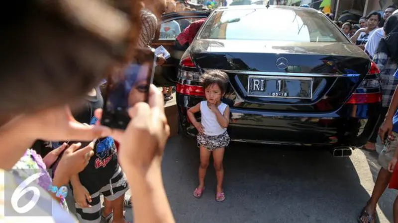 Anak kecil berfoto di belakang mobil Presiden Jokowi