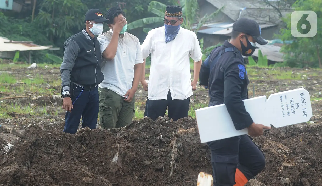 Tangis keluarga jenazah kasus COVID-19 mengunjungi pemakaman di TPU Srengseng Sawah 2, Jakarta, Selasa (9/2/2021). Sudah lebih dari sepekan TPU Srengseng Sawah 2 menerima pemakaman korban COVID-19 dengan jumlah yang dimakamkan sehari maksimal 10 jenazah. (merdeka.com/Arie Basuki)